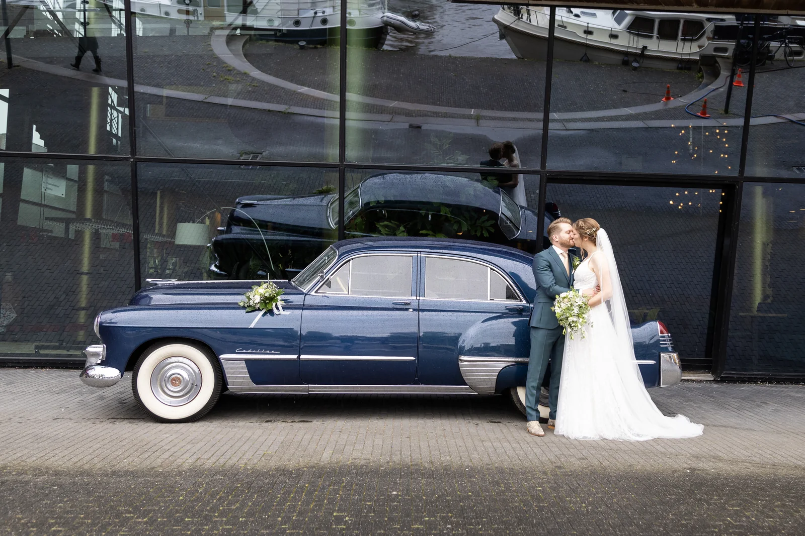 Erik en Maaike samen naast hun donkerblauwe trouw-Cadillac